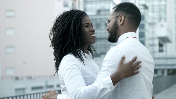 Smiling African American Woman Hugging with Friend on Street alt