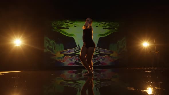 Artistic Young Woman Performing Against Dark Animated Background in Studio alt