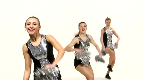 Girls in Black Costume with Pom-poms Dancing on Cheerleading Competitions, Smiling at the Camera alt