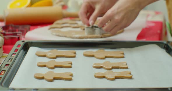 Woman Cuts Gingerbread Cookies for Christmas. Celebration. Making Gingerbread Cookies. alt