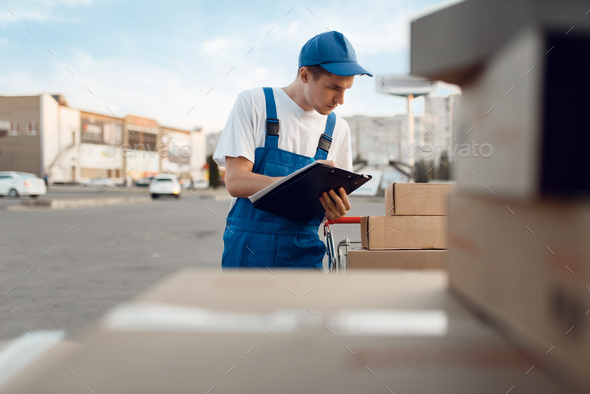 Deliveryman in uniform check parcels, delivery - Stock Photo - Images