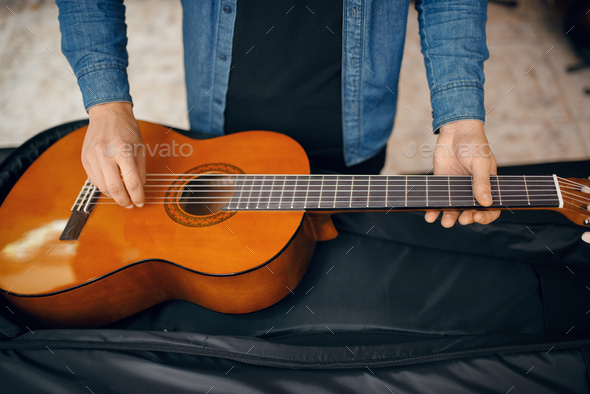 Guitarist puts guitar in the case, music store