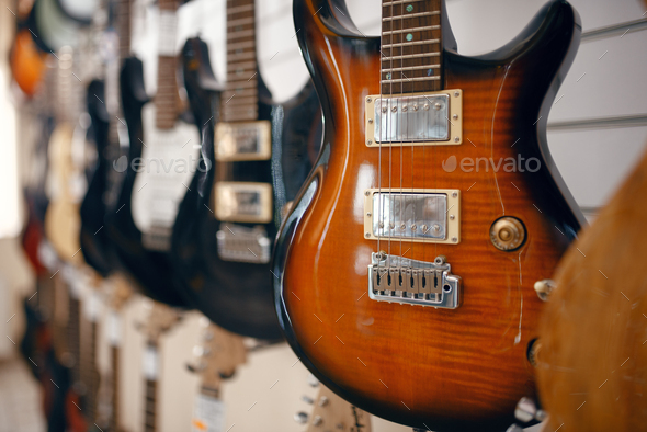 Rows of electric guitars in music store, nobody