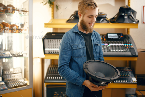 Musician buying subwoofer speaker in music store - Stock Photo - Images