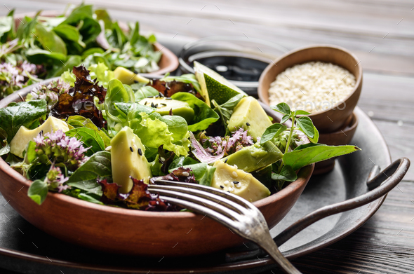 Clay dish with salad of avocado, green and violet lettuce, lamb' - Stock Photo - Images