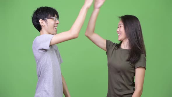 Young Asian Couple Giving High Five