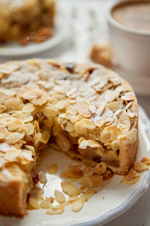 Whole delicious apple cake with almonds served on wooden table - Stock Photo - Images