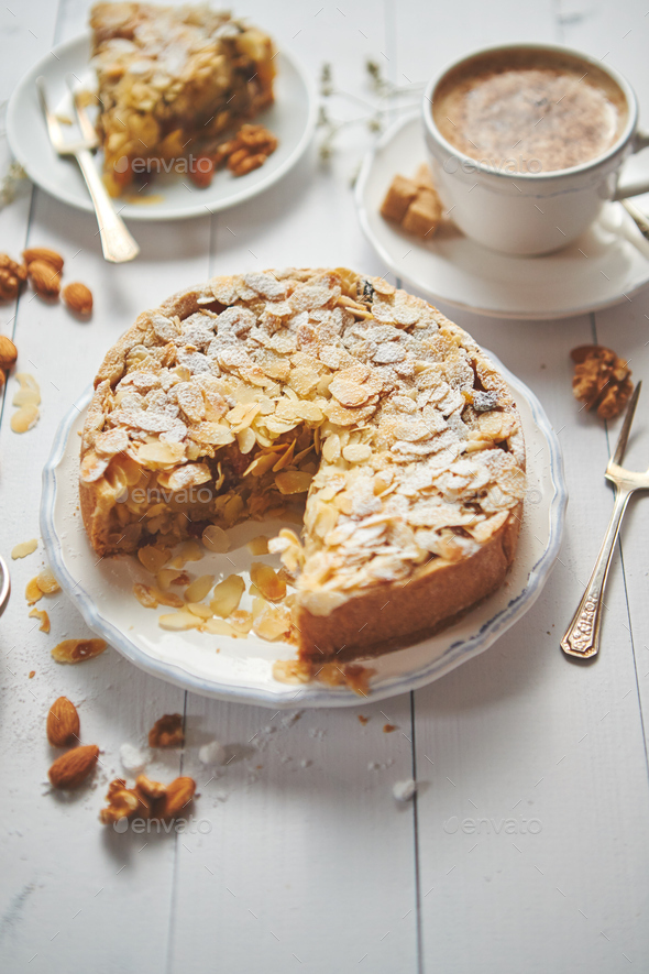 Whole delicious apple cake with almonds served on wooden table - Stock Photo - Images