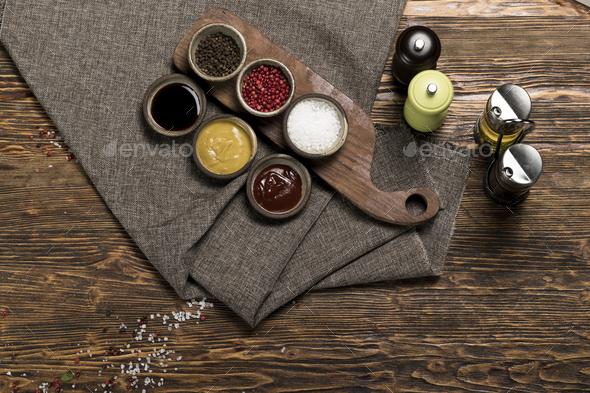 Various spices, herbs, garlic and sauces on a wooden background, studio lighting, top view - Stock Photo - Images
