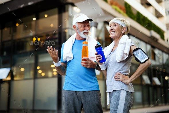 Healthy senior, couple jogging in the city at early morning with sunrise