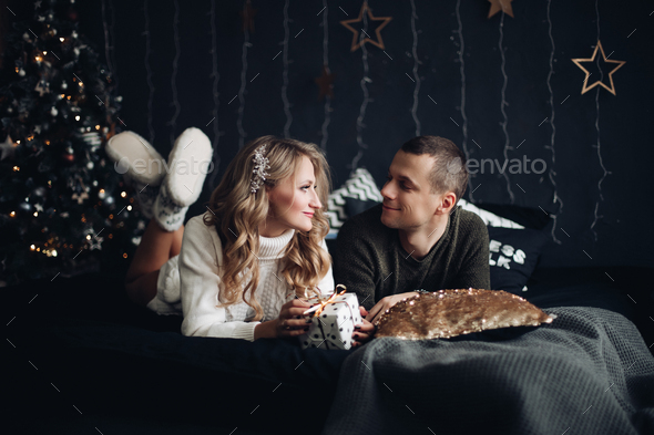 Couple on bed with Christmas present. New Year - Stock Photo - Images