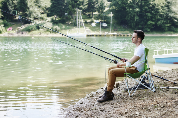 Men with fishing rod sitting on fishing chair