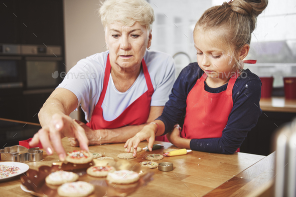 Grandma and granddaughter decorating cookies