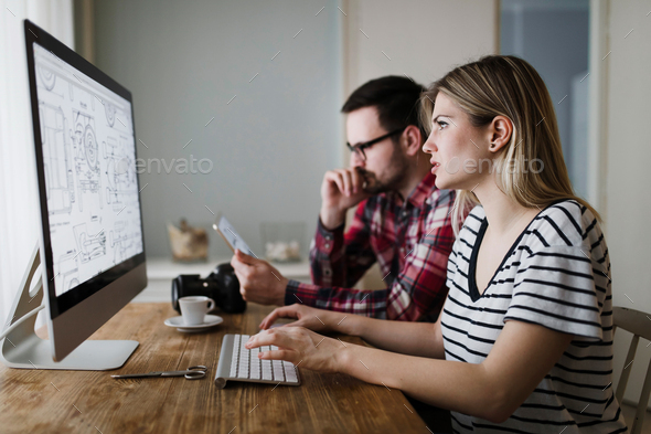 Beautiful woman and attractive man doing design work