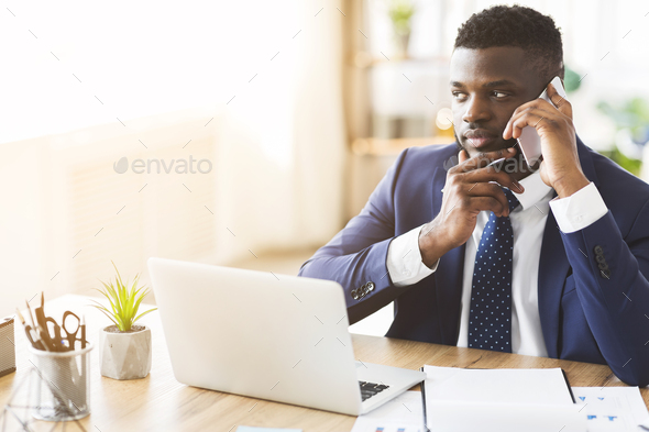 Young entrepreneur having conversation with business partner by cellphone