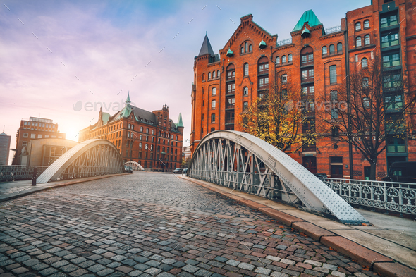 Arch bridge over alster canals with cobbled road in historical Speicherstadt of Hamburg, Germany - Stock Photo - Images