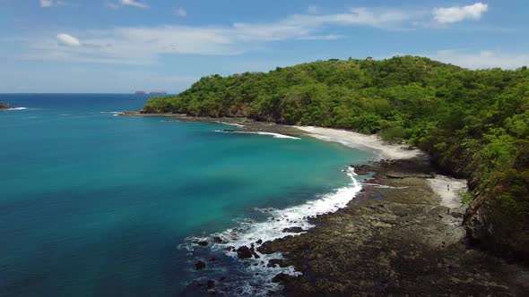 Tropical hidden white sand and blue turquoise water beach in Costa Rica. Aerial view in 4K alt