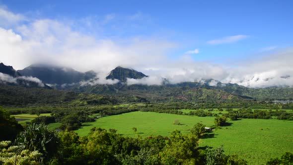 Kauai sunny day green land and cloudy mountains view
