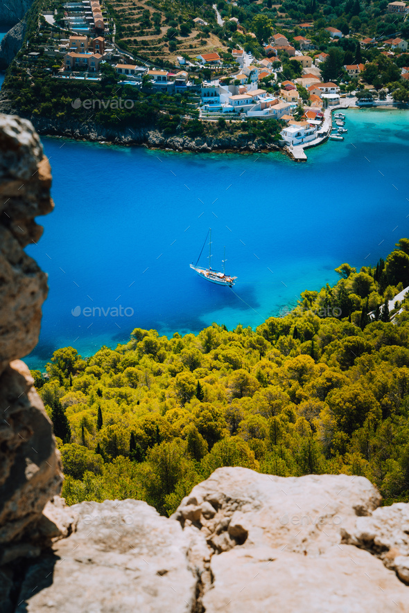 Epic view to blue bay of Assos village Kefalonia from Fortress above. White yacht at anchor in calm - Stock Photo - Images