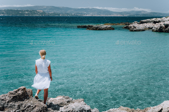 Jung adult women in white dress on summer vacation in front of sea coast landscape of small beach - Stock Photo - Images