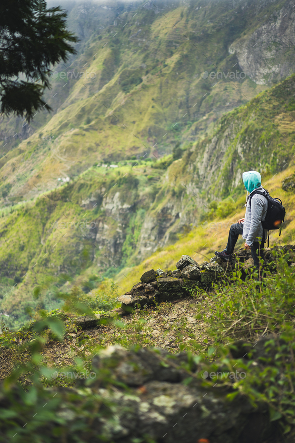 Tourist with backpack looking over the rural landscape with mountain ridge on the path to the Xo-Xo - Stock Photo - Images