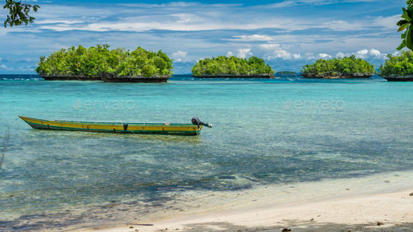 Papua Local Boat, Beautiful Blue Lagoone near Kordiris Homestay, Small Green Island in Background - Stock Photo - Images