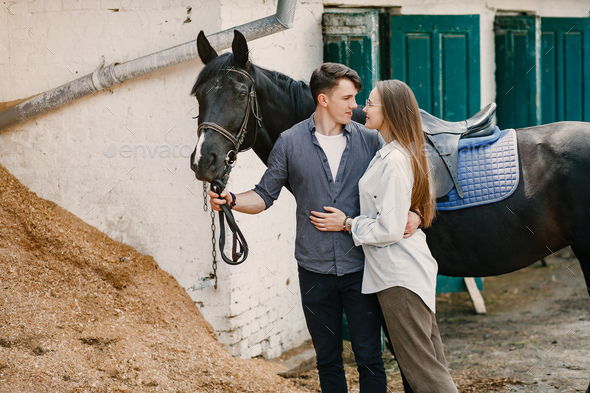 Cute loving couple with horse on ranch