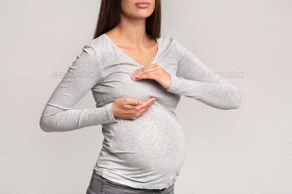 Unrecognizable Pregnant Lady Suffering From Breast Pain Standing, Gray Background