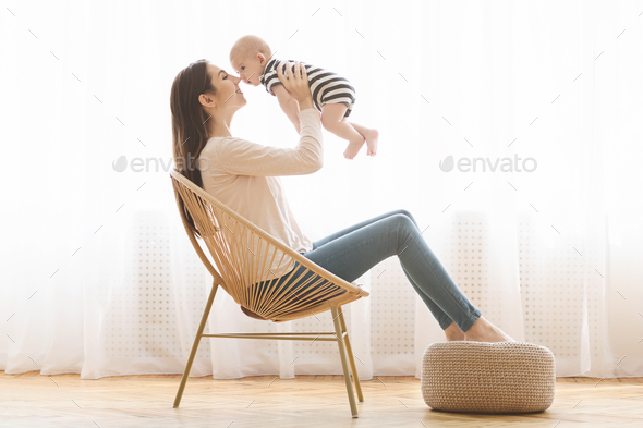Happy mom spending time with her newborn baby at home - Stock Photo - Images