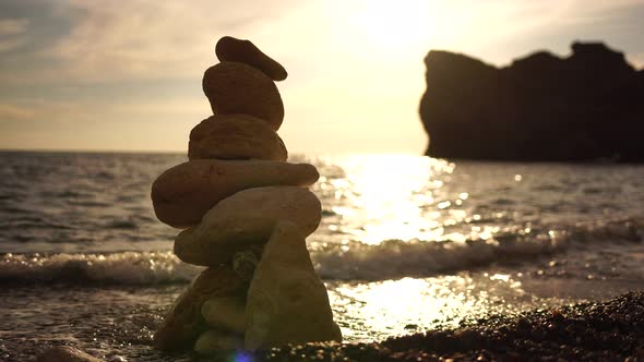 Pyramid Stones on the Seashore on a Sunny Day on the Blue Sea Background alt
