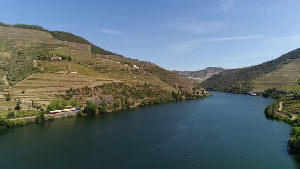 Train crossing the banks of the river Douro Portugal alt