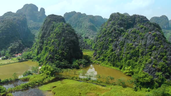 Aerial: North Vietnam karst landscape at sunset, drone view of Ninh Binh region, tourist destination alt