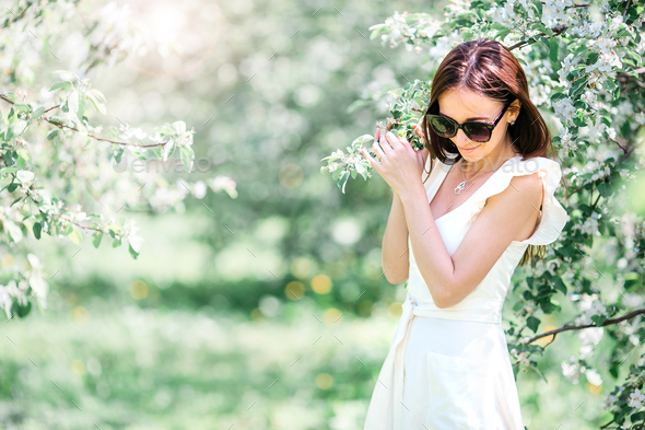 Beautiful woman enjoying smell in spring cherry garden - Stock Photo - Images