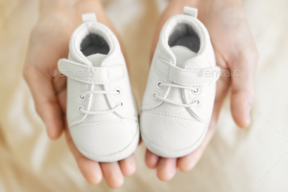 Small cute baby shoes in fathers hands 
