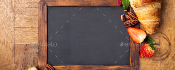 Black chalkboard with croissant and berries - Stock Photo - Images