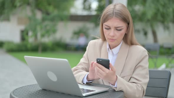 Attractive Young Businesswoman Using Smartphone in Outdoor Cafe alt