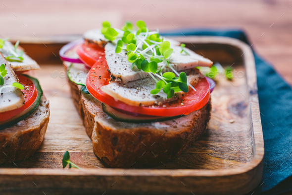Sandwiches with turkey meat and fresh vegetables served with microgreens - Stock Photo - Images