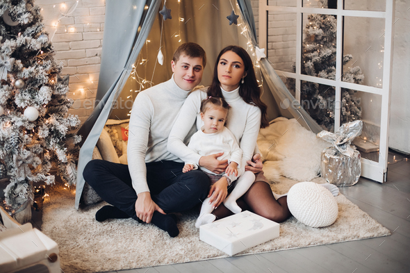 Beautiful young family under baldachin. Christmas decorations - Stock Photo - Images