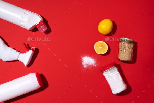 Baking soda, lemon and mustard powder against household chemicals products over red background. Top - Stock Photo - Images