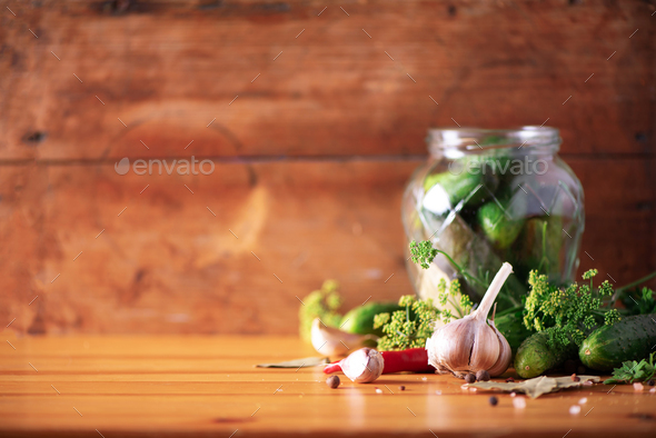 Pickling cucumbers in cans. Ingredients for marinated gherkins, glass jar, garlic, dill, salt - Stock Photo - Images