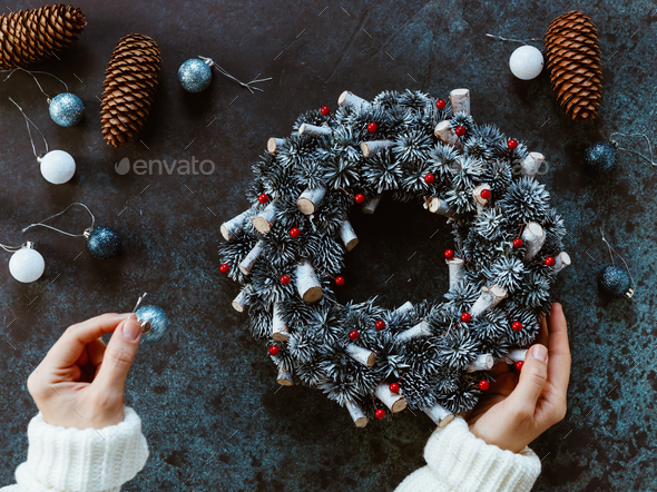 Girl's hands in a winter white sweater hold a Christmas holiday wreath - Stock Photo - Images
