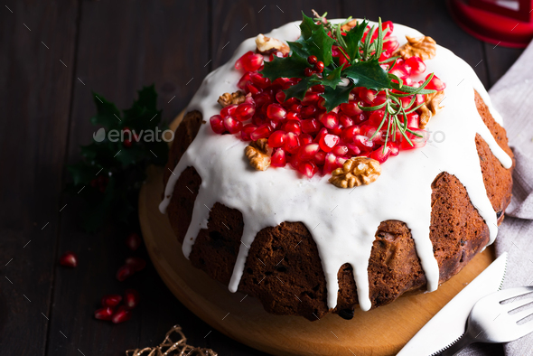 Christmas chocolate cake with white icing and pomegranate kernels on a wooden dark background with - Stock Photo - Images