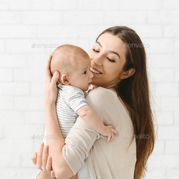 Portrait of young mother cuddling her adorable little child - Stock Photo - Images