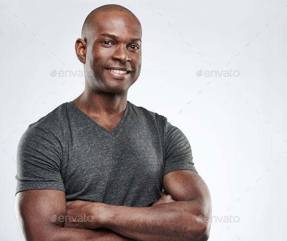 Man with folded muscular arms looking ahead - Stock Photo - Images