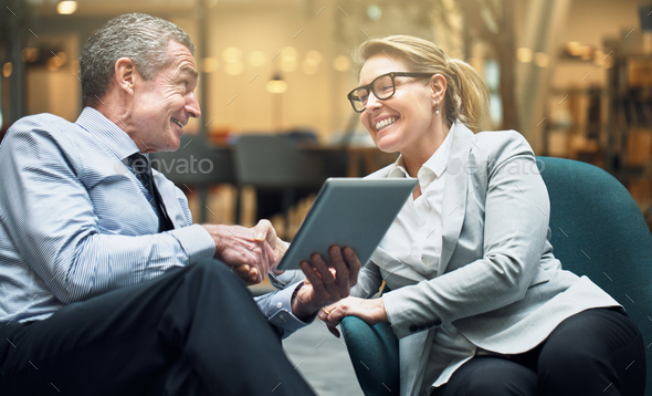 Smiling businesswoman shaking hands with a colleague in an office - Stock Photo - Images