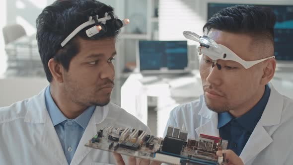 Male Engineers Examining Motherboard in Laboratory alt