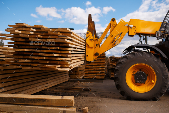 Forklift loads the boards in the lumber yard - Stock Photo - Images