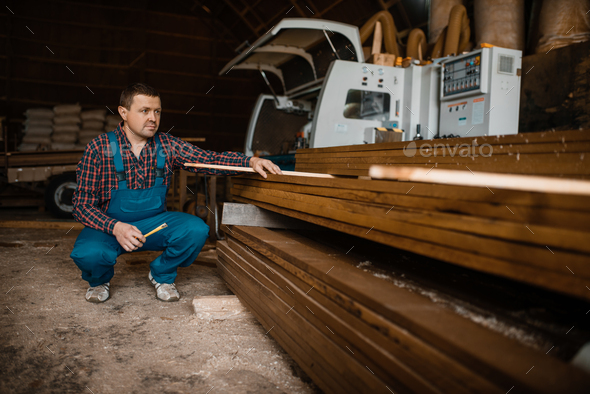 Carpenter in uniform at his workplace on sawmill - Stock Photo - Images