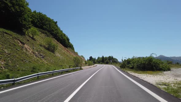 Moving view (car, motorbike or bicycle) of a mountain landscape