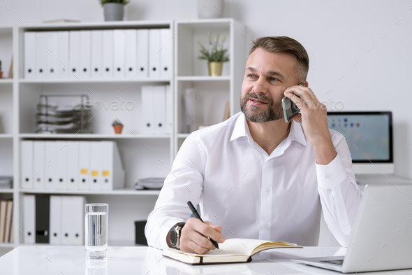 Bearded confident director of business company phoning client or partner